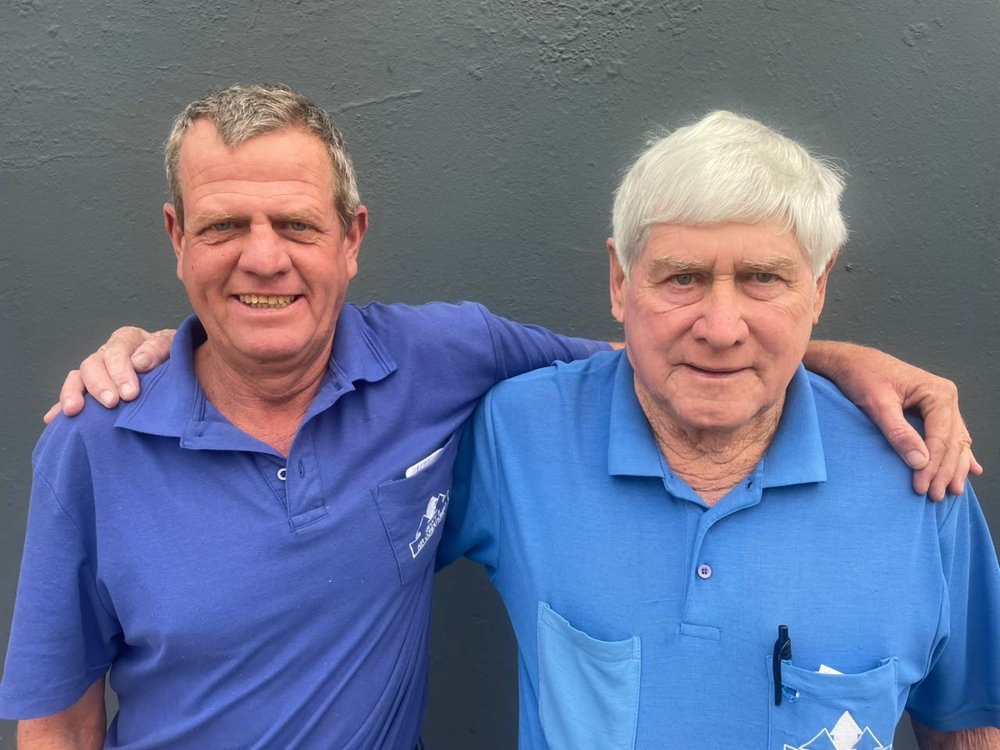 Geoff and his son Steve standing arm-in-arm outside their East London workshop